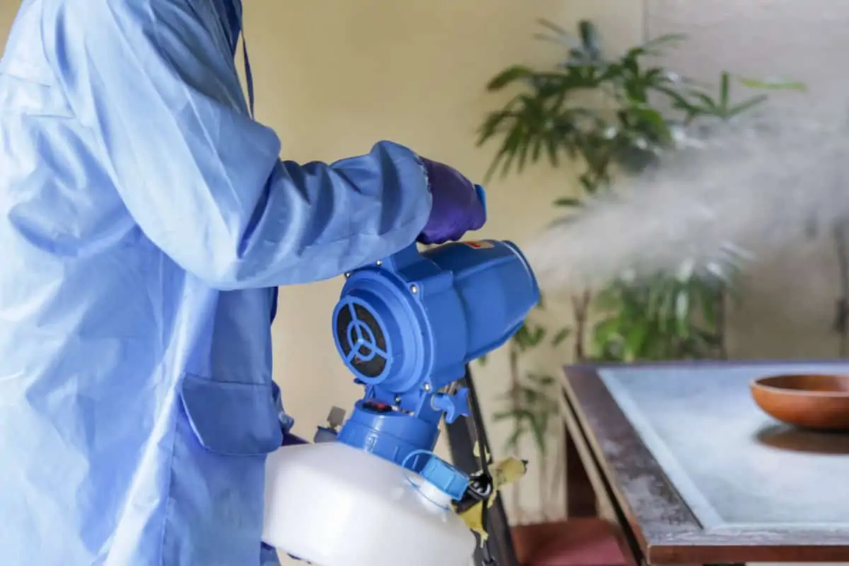 California mold remediation technician in protective gear using Dry Fog equipment for Cali Mold Removal